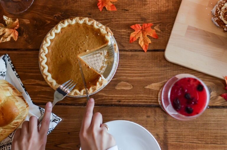 person slicing pumpkin pie